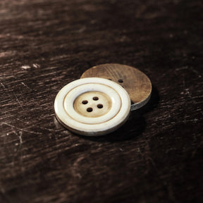 Stor benknapp, 30mm diameter, naturlig ben- och vallnötsfärg med synliga svarvarlinjer och fyra håll, handarbetet svarv-detaljer