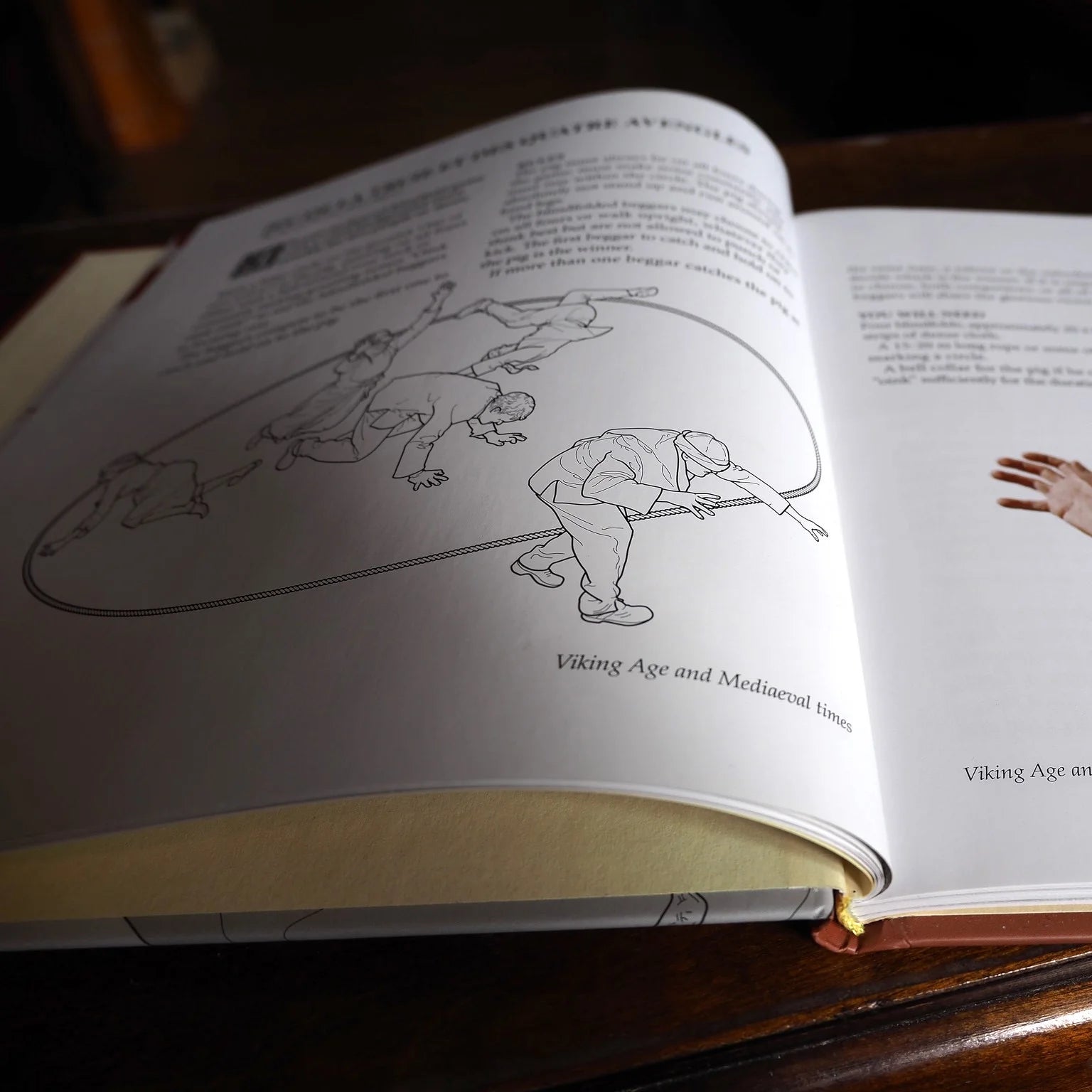 Bokfotografi visar öppen sida med illustrationer av vikingatids lekar med rep och snara, med engelsk text som förklarar historiska tävlingsregler från medeltid