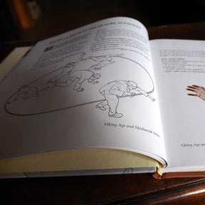Bokfotografi visar öppen sida med illustrationer av vikingatids lekar med rep och snara, med engelsk text som förklarar historiska tävlingsregler från medeltid