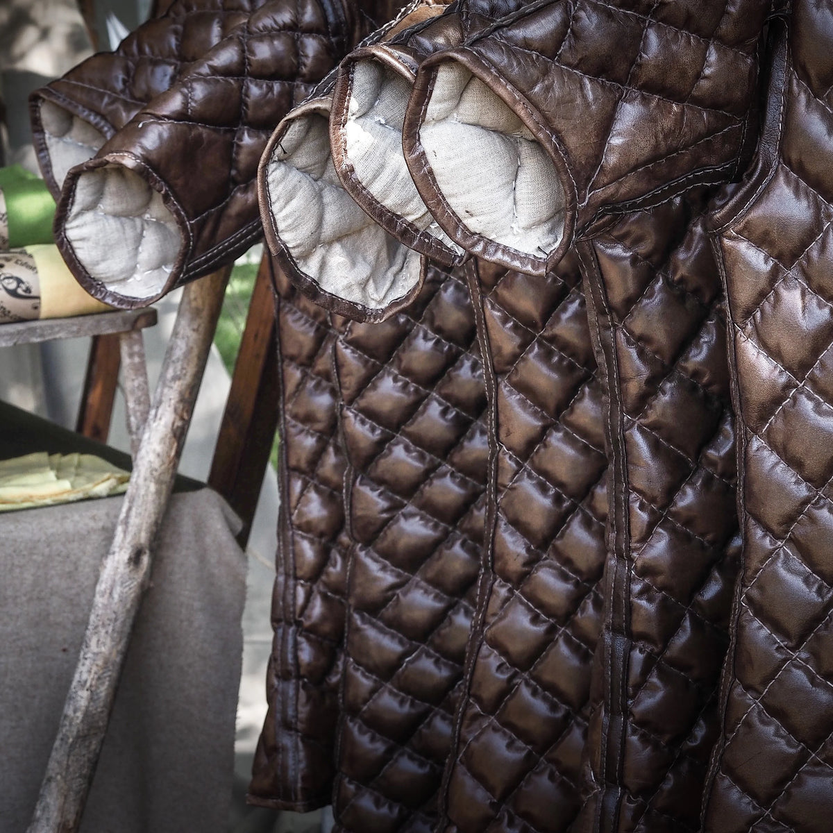 Närbild av Gambasong-stridsjackan som visar diamantöverst quiltat läder med linneunderlägg för medeltida stridsprotekton.