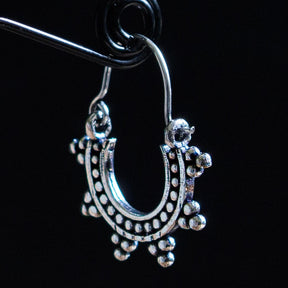 En liten solinspirrerad örhänge i silveröverlagring mässing med ornamental design och hängande detaljer