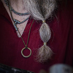 Two beard beads with heart-shaped embossed centers and beaded frame borders in contrasting finishes