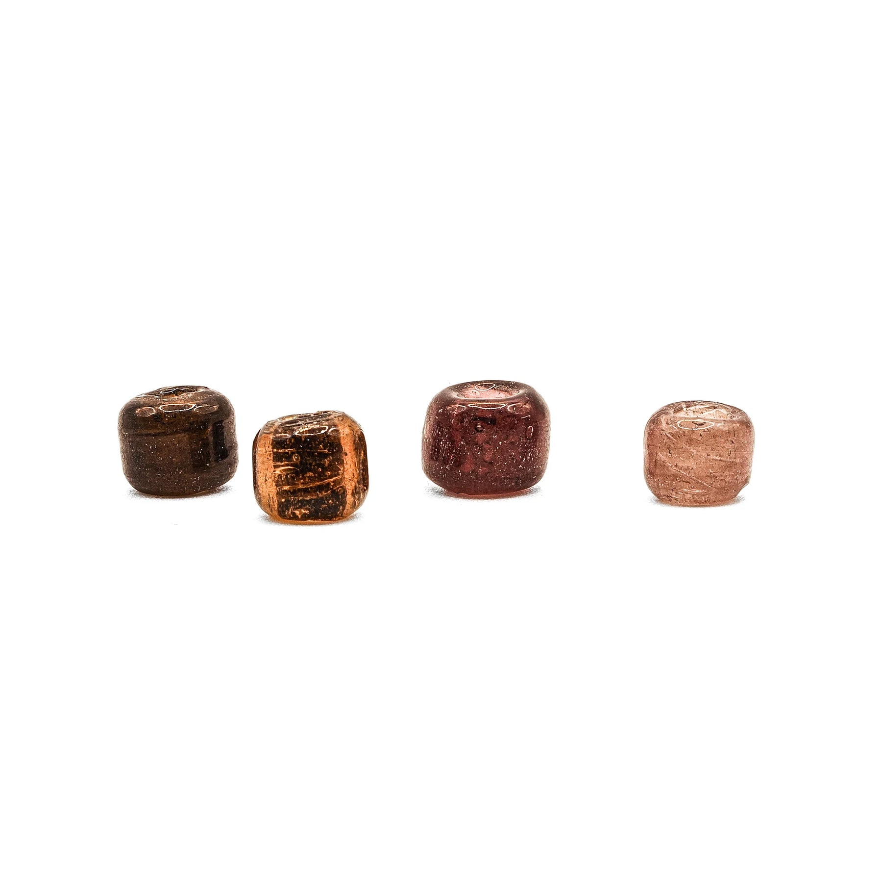 Fyra antika glaspärlor i mörkbrun, orange, röd och rosa färg - alternativ vy på vit bakgrund