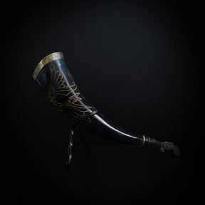 Dryckeshorn med gravyr - mörkbrun organisk horn med mässingsband och graverad korp i guldtone. Klassisk vikinginspirerad designad drinkningshorn, cirka 250 ml.