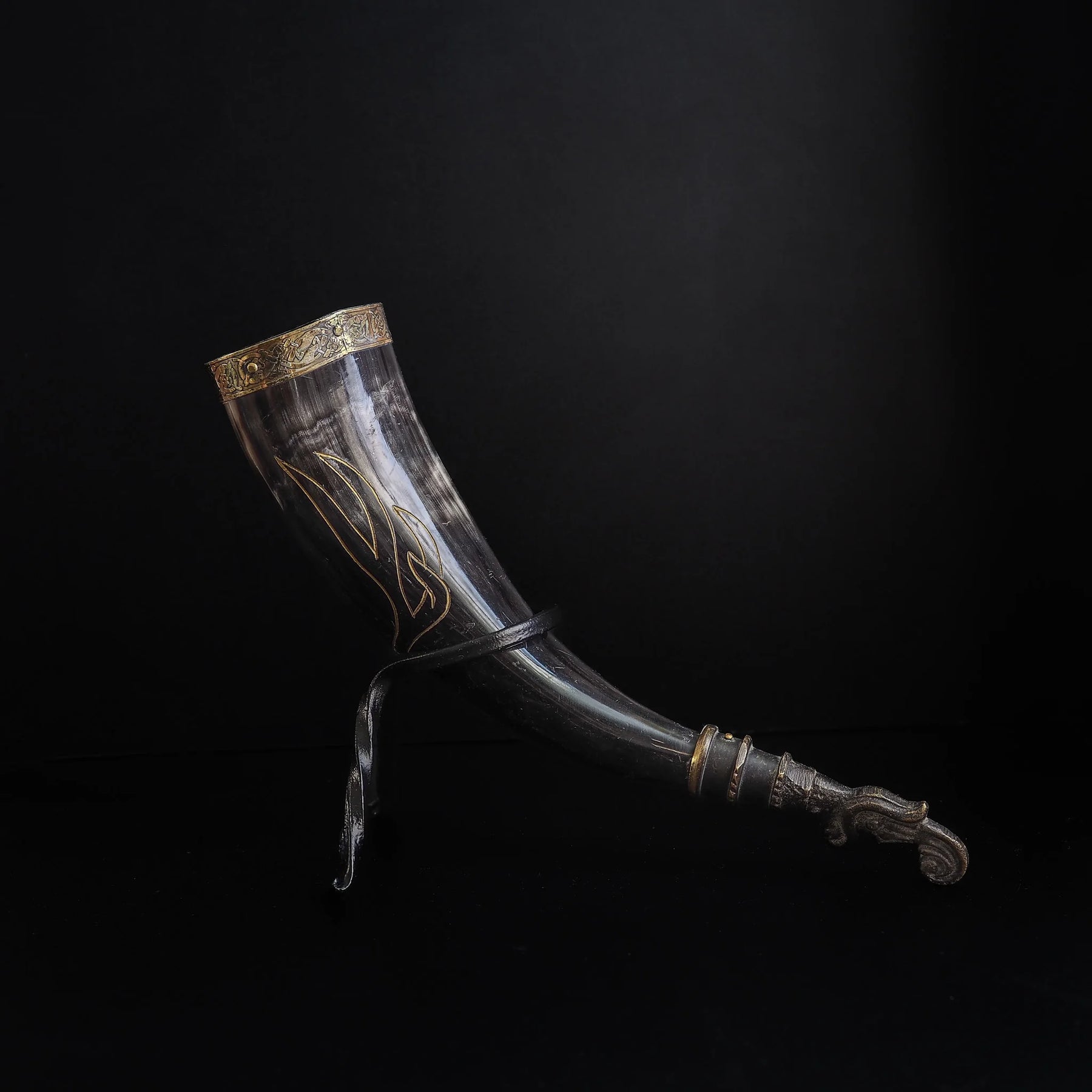 Närbild av hornets graverade detaljer. Norska runor och vikingtid bindmönster synliga. Organisk hornstruktur med djupa gravyrer.