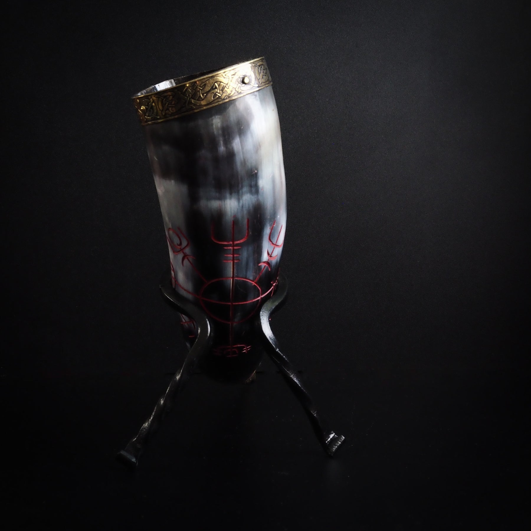 Dryckeshorn i naturligt horn, presenterat upprätt. Graverad solhjul med runor i hornet. Mässingsbågar och dekorativ topp skapar klassisk vikingastil.