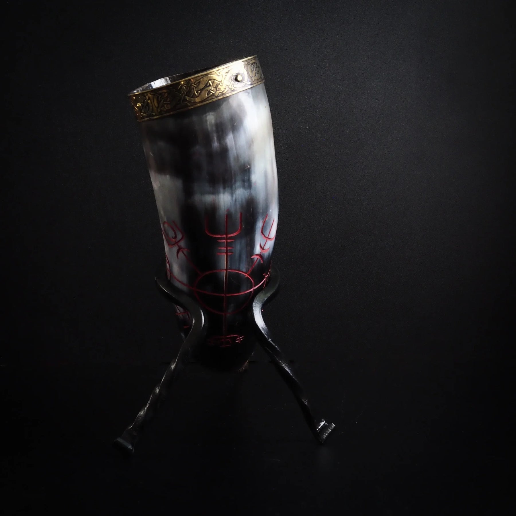 Dryckeshorn i naturligt horn, presenterat upprätt. Graverad solhjul med runor i hornet. Mässingsbågar och dekorativ topp skapar klassisk vikingastil.