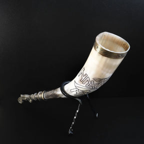 Sida detalj av dryckeshornets övre del. Naturligt horn material med translucent kvalitet. Graverad design med korpar vingar och vikingaskepp. Mässingsbåge visar fint norskt hantverk.