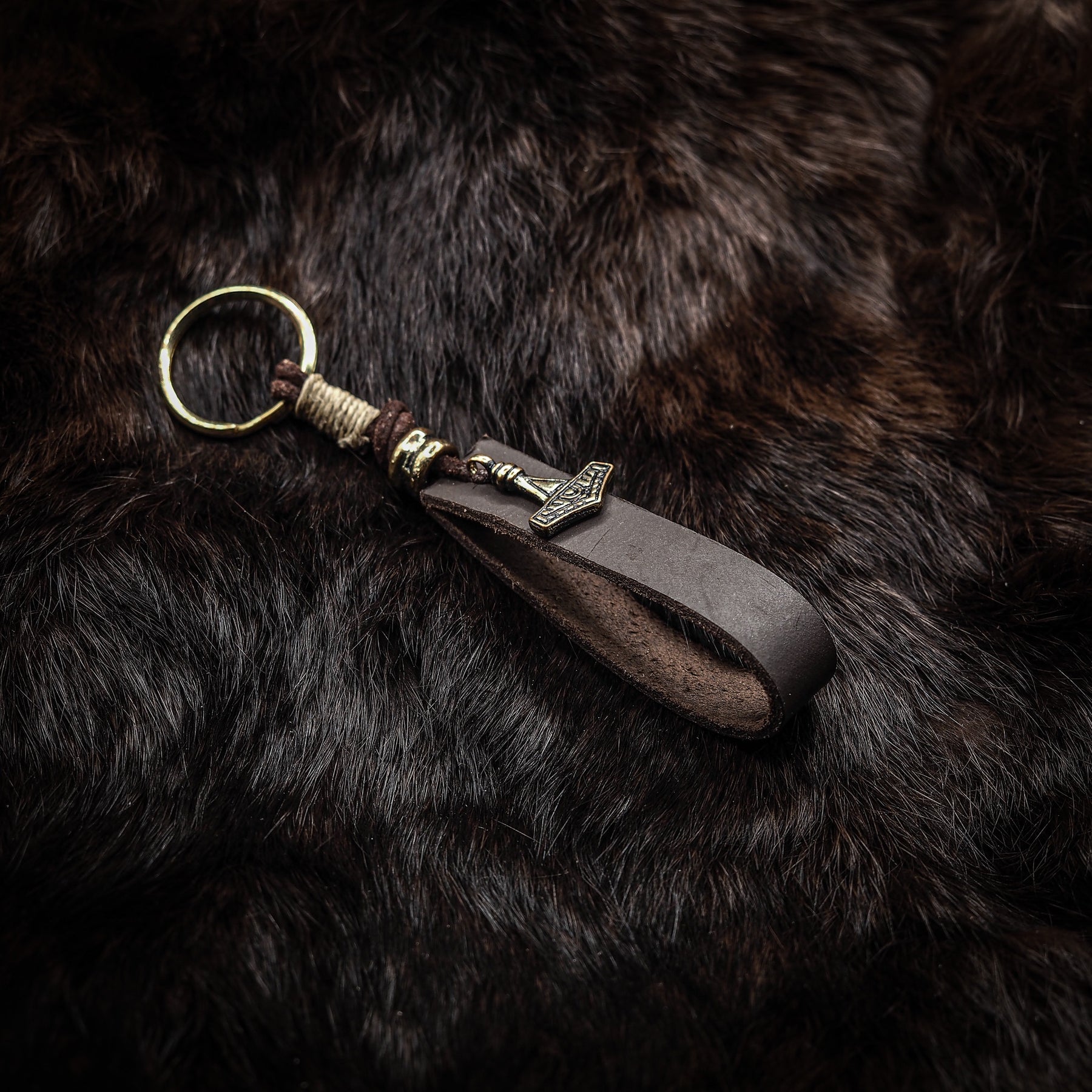 Liten Torshammare nyckelring i brons med läderband och handflätning, visar klassisk nordisk symbol