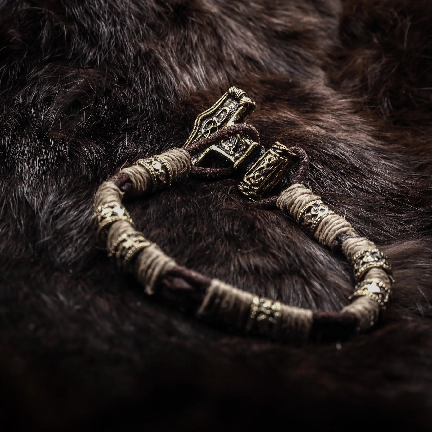 Kraftigt armband med Torshammare (Mjölnir) i silver och läder på mörkpälsbakgrund