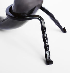 Närbild av polerad hornmugg med lädergrepp, visar naturlig glans och slitage på handslipat material