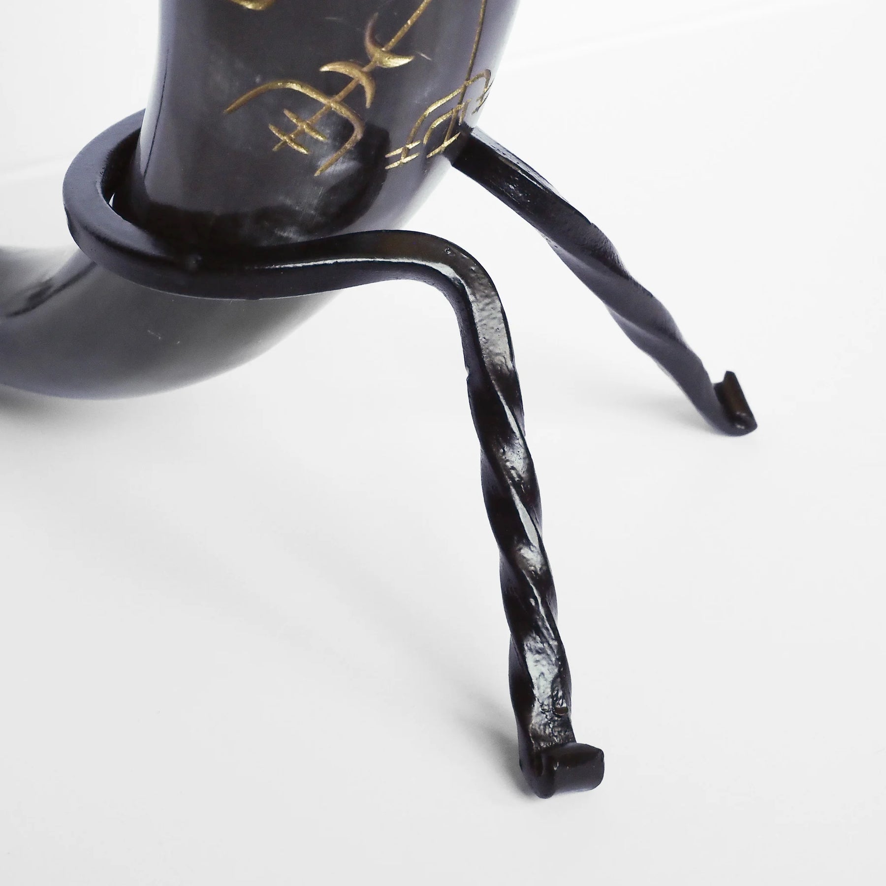 Närbild av dryckeshorns fot och stöd med spiralvriden mässing, visar detaljerat metallarbete och monteringssystem