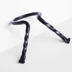 Två smidda järnställ för hornkoppar med böjd design, visande det öppna 60 mm-formatet mot vit bakgrund