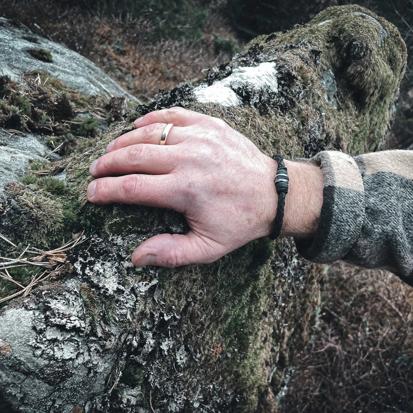 Eitre Vikingaarmband på äldre mans handled, svart läder med metallband, utomhus i naturlig miljö