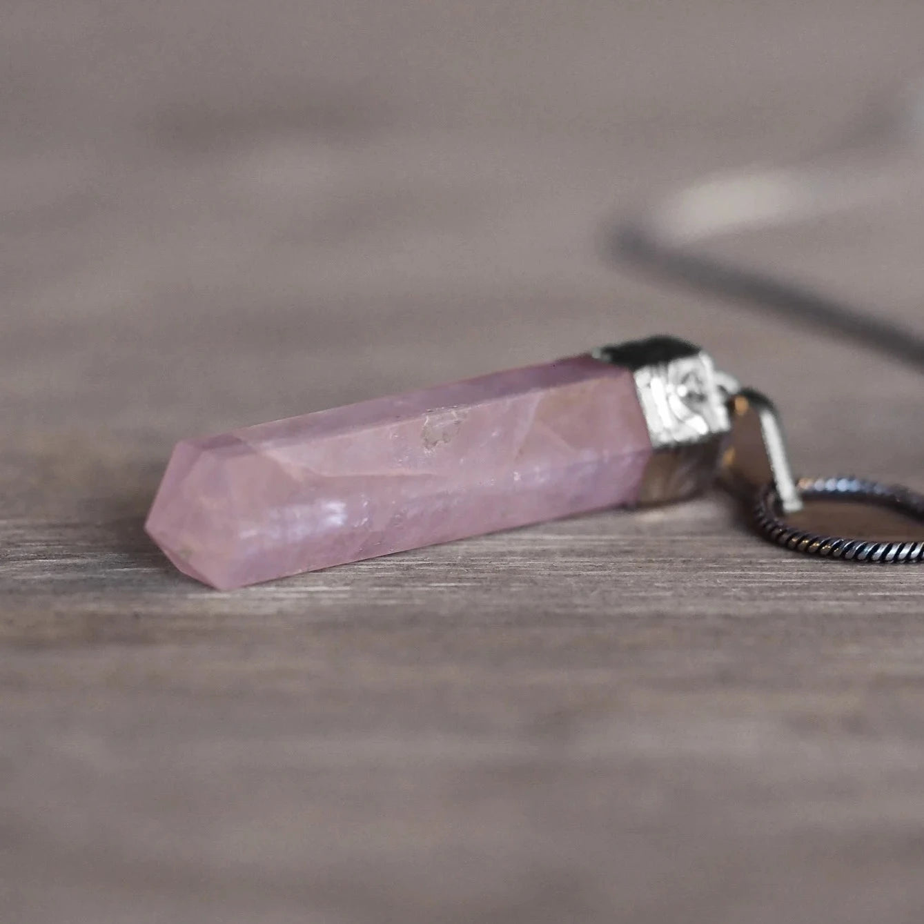 Rosenkvarts stenhänge - polerad rosa kvarts i mässingsfäste med mörkgrå pärlebandshalsband