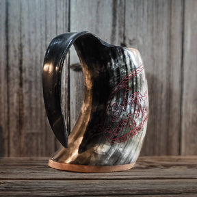 Närbild av Sigurdsagan-gravering som visar röd eller kopparfärgad inlägg i de graverade spåren. Krigarfigurer, drake och runor är väl framställda med tydlig 3D-effekt från gravyrarbetet.