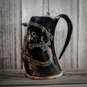 Svart graverad hornmugg med Sigurdsagan-motiv. Runor och figurer från den norska sagan är inskurna runt muggen. Naturligt hornmaterial med trä- och hornbotten.
