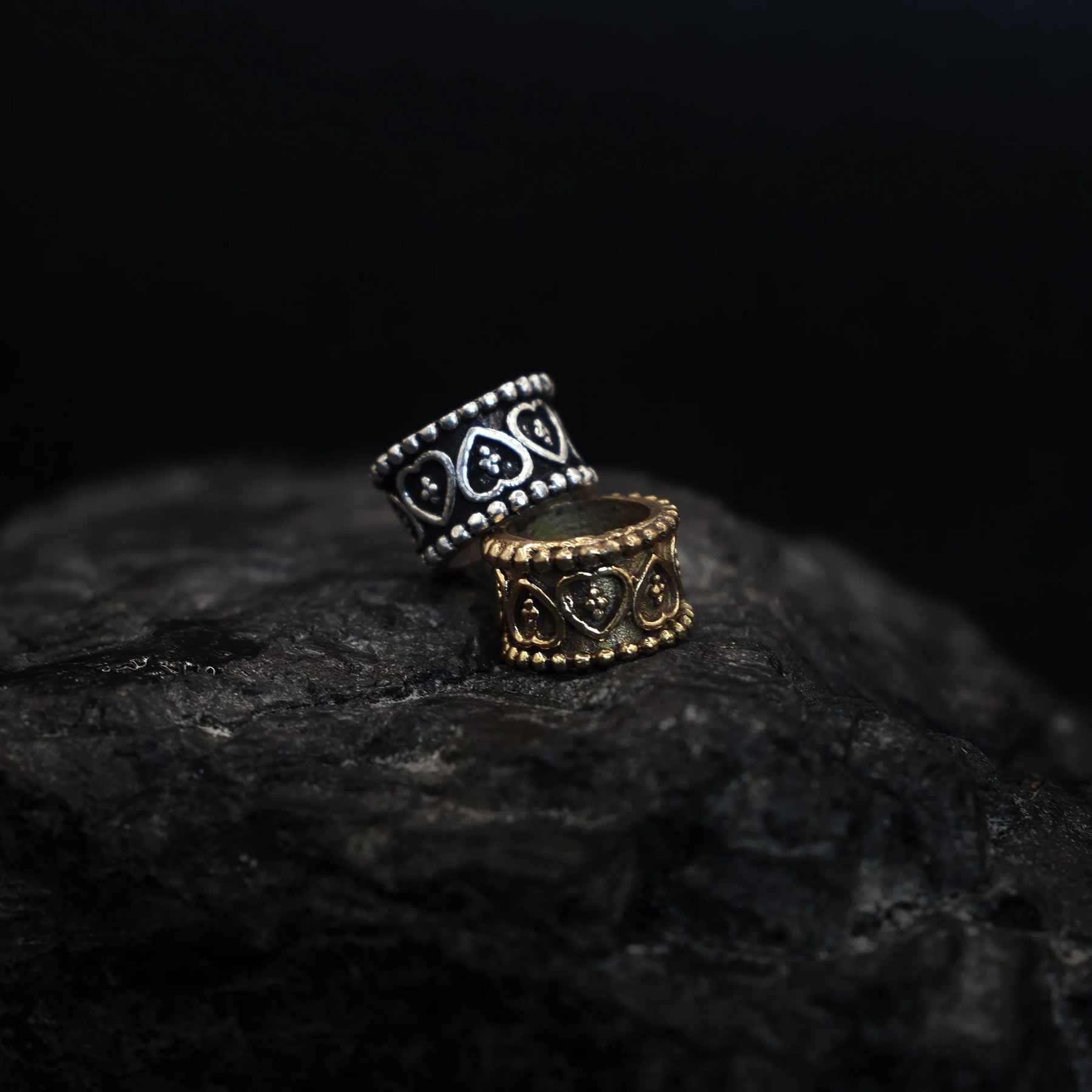 Two brass beard beads with heart-shaped centers and beaded borders in silver and gold finish