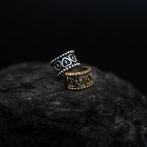 Two brass beard beads with heart-shaped centers and beaded borders in silver and gold finish