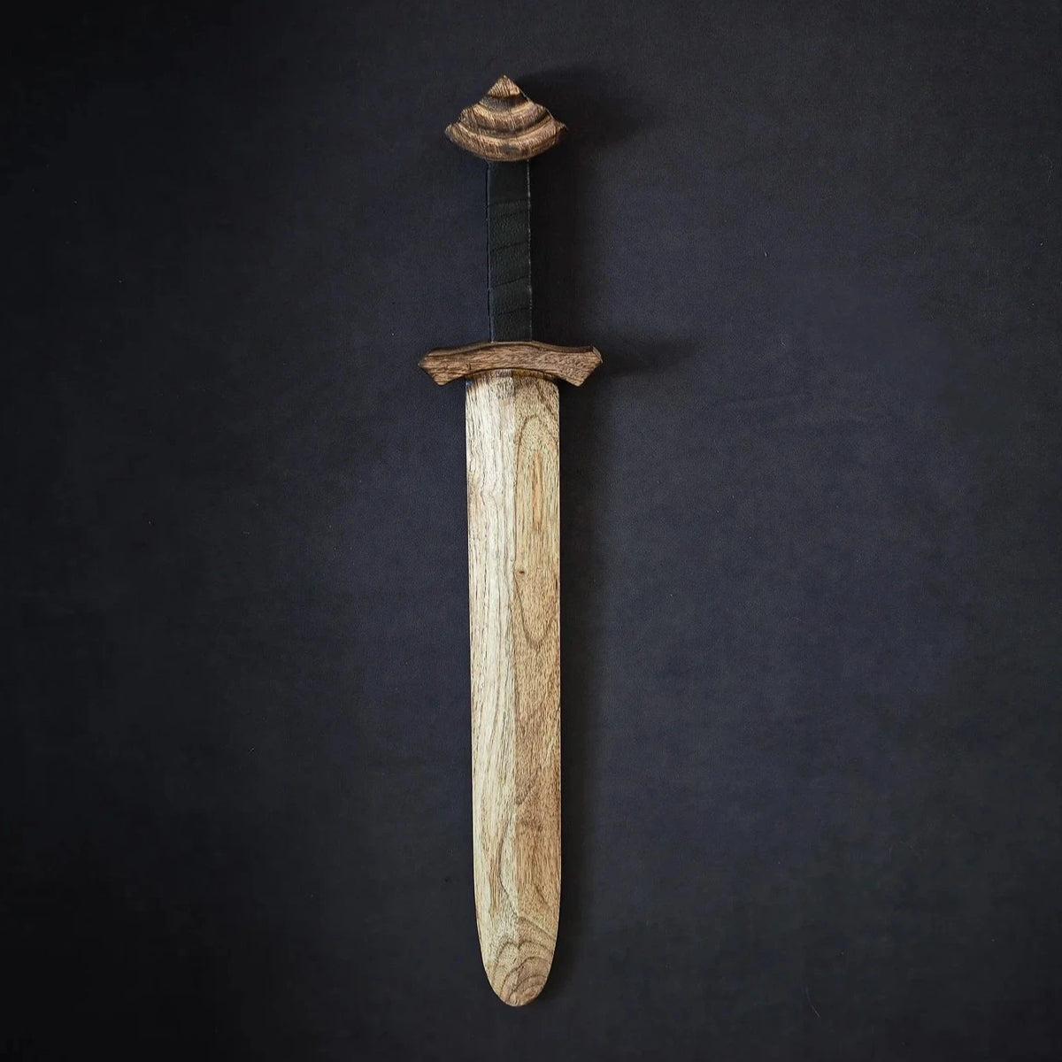 Wooden Jarl sword with intricately carved geometric pommel, black leather-wrapped grip, and refined blade
