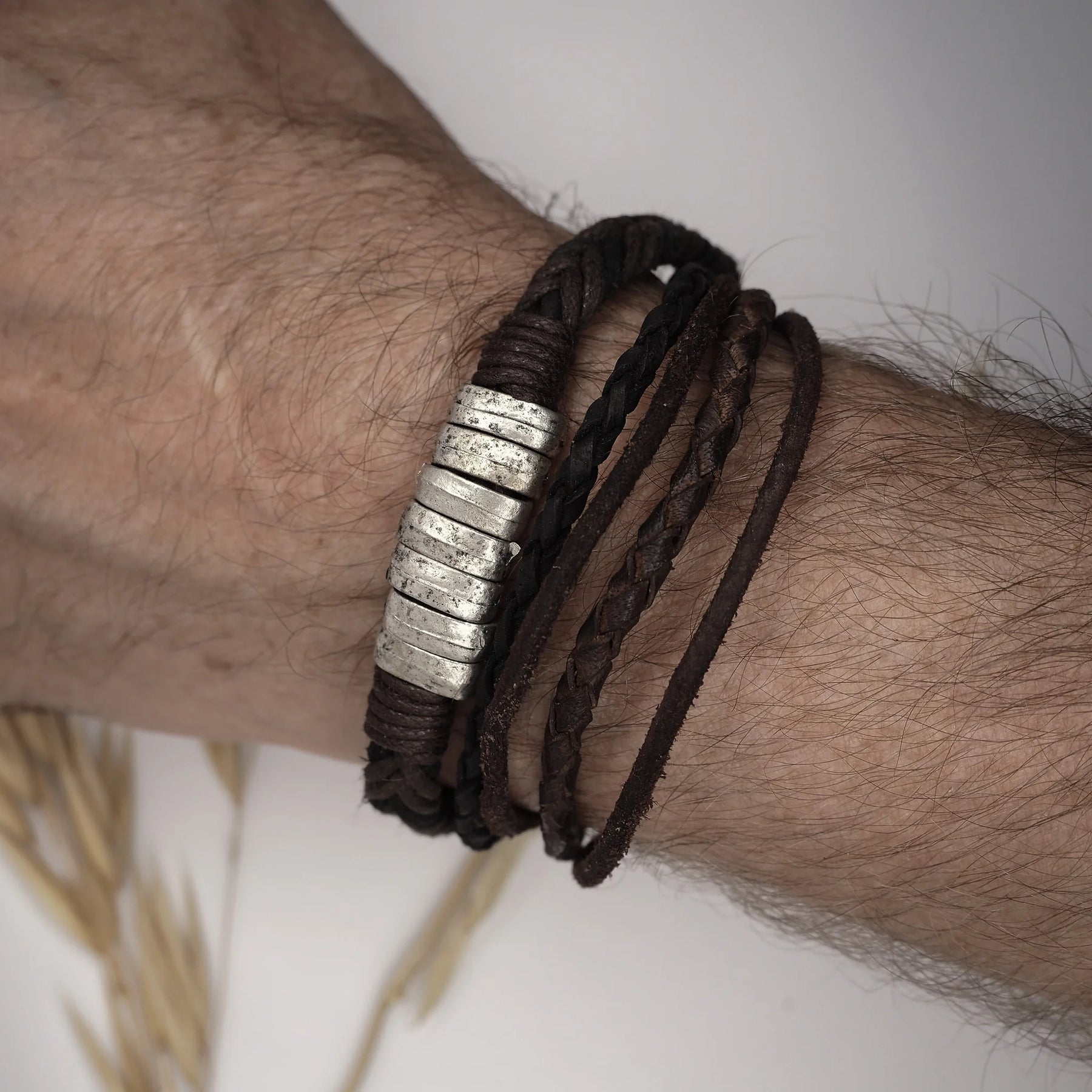 Tre-trådigt armband i brun läder med silverband på herrvrist, visar passform