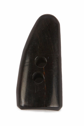 En hornknapp i organiskt horn med mörk färg och glänsande yta. Långsträckt spetsig form med två hål. Visar autentisk hornmaterial och hantverk.
