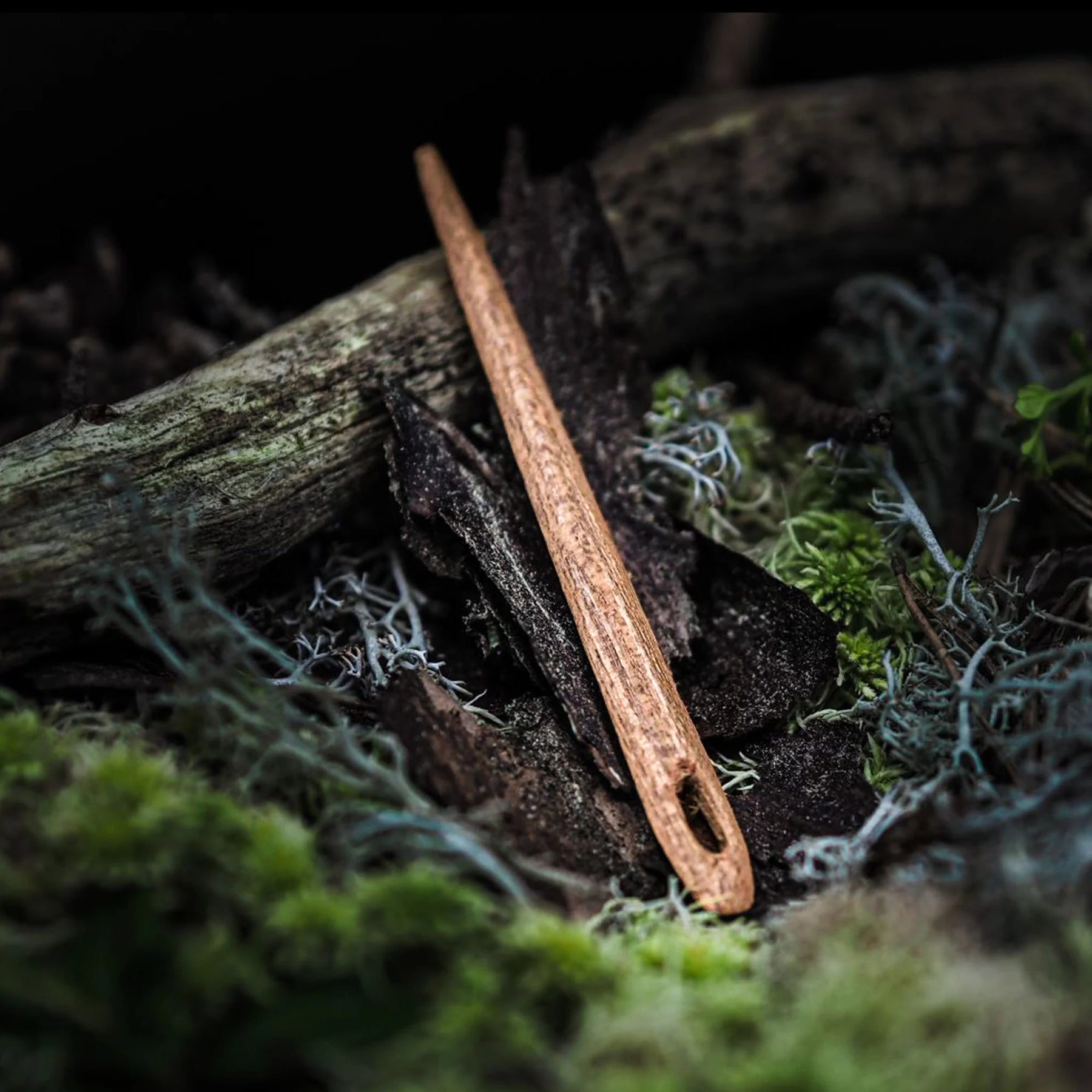 Nålbindingsnål i trä, omkring 7 cm långt med naturlig trästruktur och handslipat design med ögla