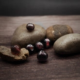 Loose handmade glass beads in muted purple color, approximately 7-8mm diameter with through hole for threading