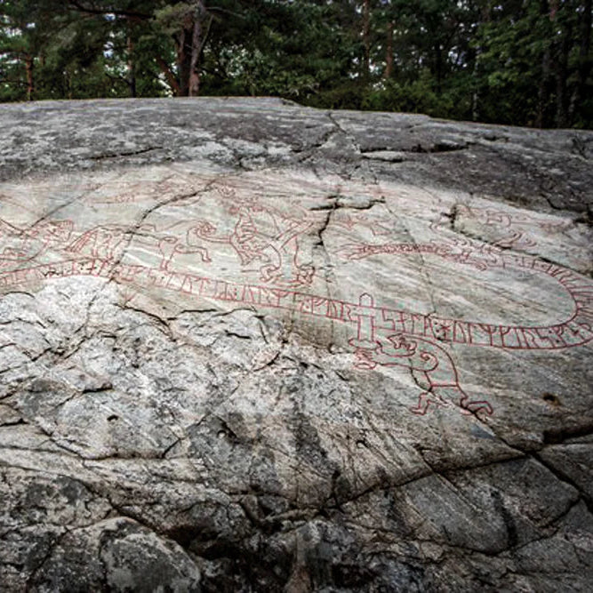 Historisk runsten från Sundbyholm med Sigurds-ristning. Röda runor och snidade figurer från vikingatiden syns på granitytan. Ancient Nordic monument som inspirerat muggdesignen.