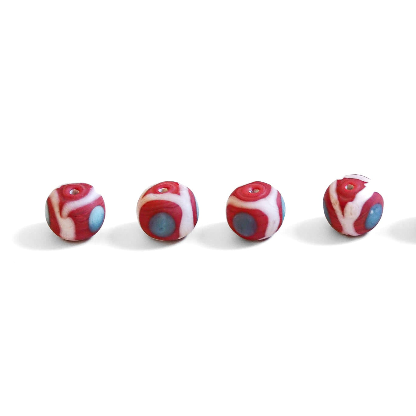 Red glass bead with white and blue-gray pattern, matte finish, approximately 14-18mm diameter, Viking-era inspired design