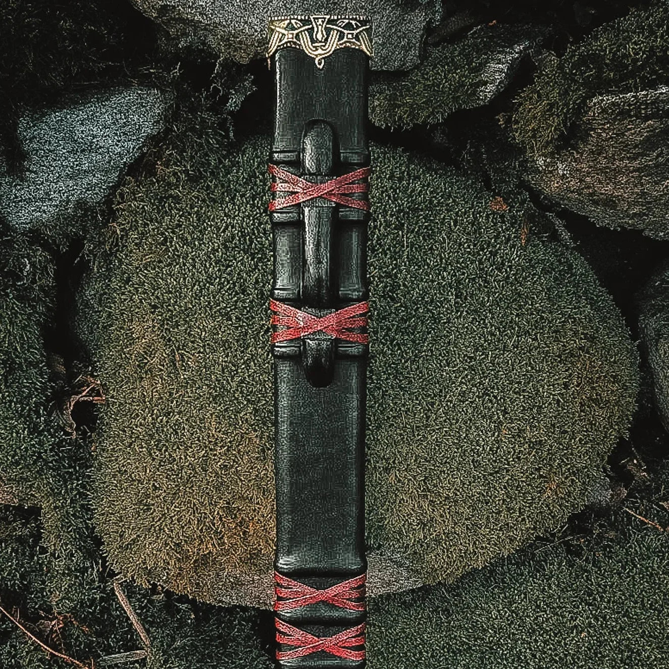 Svärdskida, Golden honor premium - svart läderslida med röda X-lindningar och bronsad vikingornamenter, på stenar