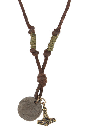 Halsband Enride på vit bakgrund, visar Torshammaren i mässing tillsammans med antikt vikingamynt, båda hängande från brunt läderband med naturfiber-lindning.