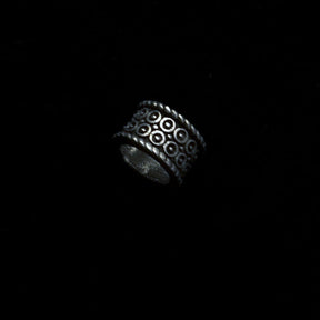 Birnir brass beard bead rotated to show full relief sun symbol pattern and hollow tube construction
