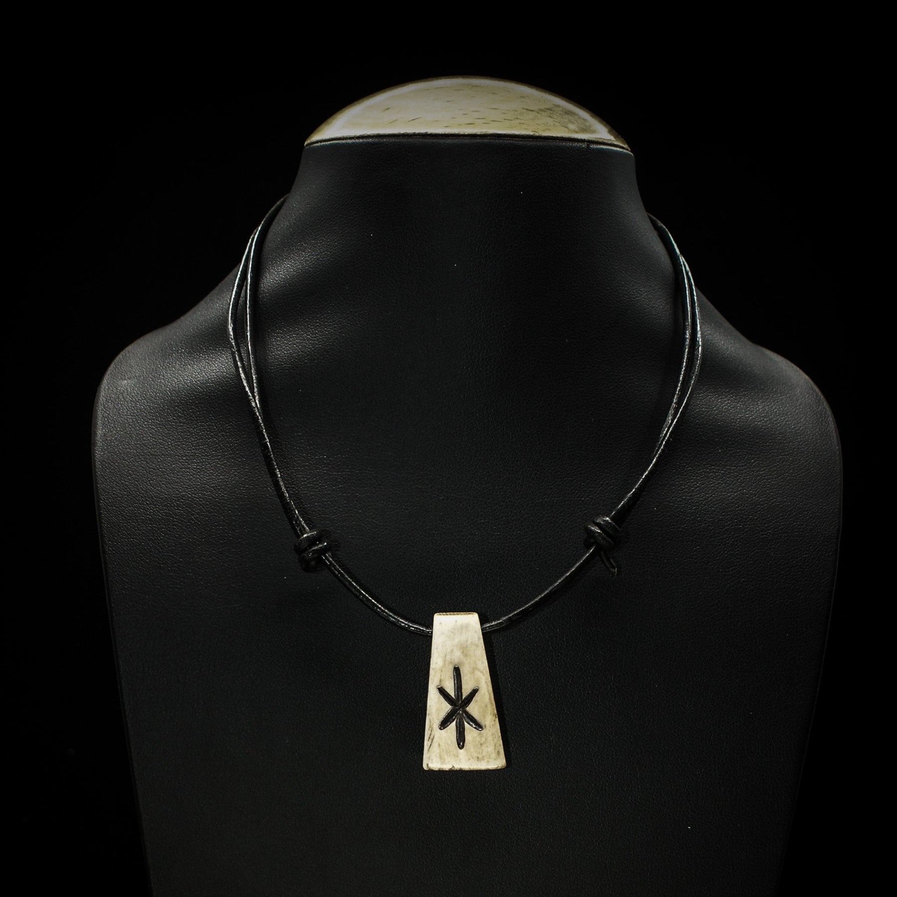 Nordiska Runor i ben: Algiz-runan (Y-format) graverad i ben på svart lädersnöre. Traditionell Elder Futhark-symbol på handgjord benrosett.