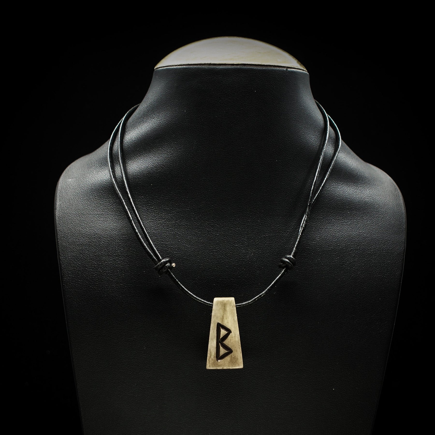 Nordiska Runor i ben-halsband på svart lädersnöre med Berkano-runan (ᛒ) på mannekäng, visar praktisk bärbarhet och längd.