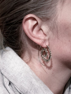 Stora mässingsörhängen spiralmönster med dekorativa droppar.