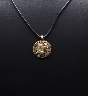 Bronshängsmycke med evighetssymbol och spiralmönster upphängd från mörk skinnkord mot svart bakgrund, skarpt produktfoto