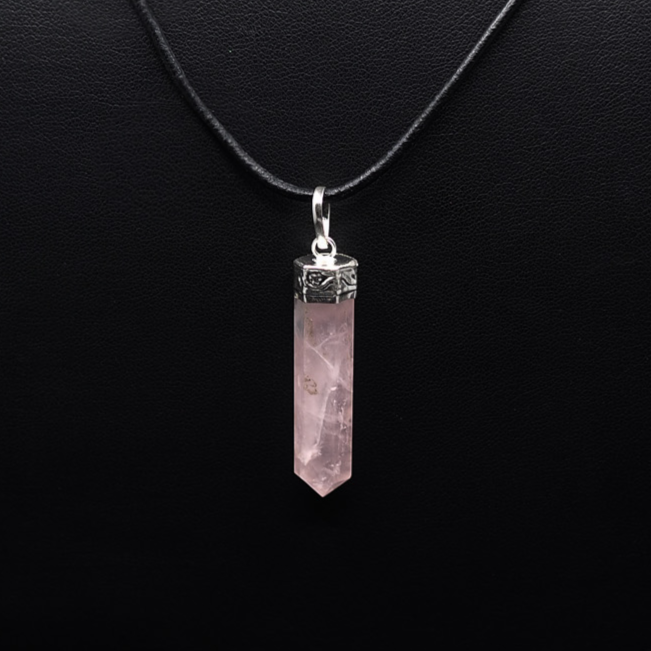 Stenhänge med rosenkvarts på silvrig kedja mot svart bakgrund, mjuk rosa translucent sten för kärlek och harmoni