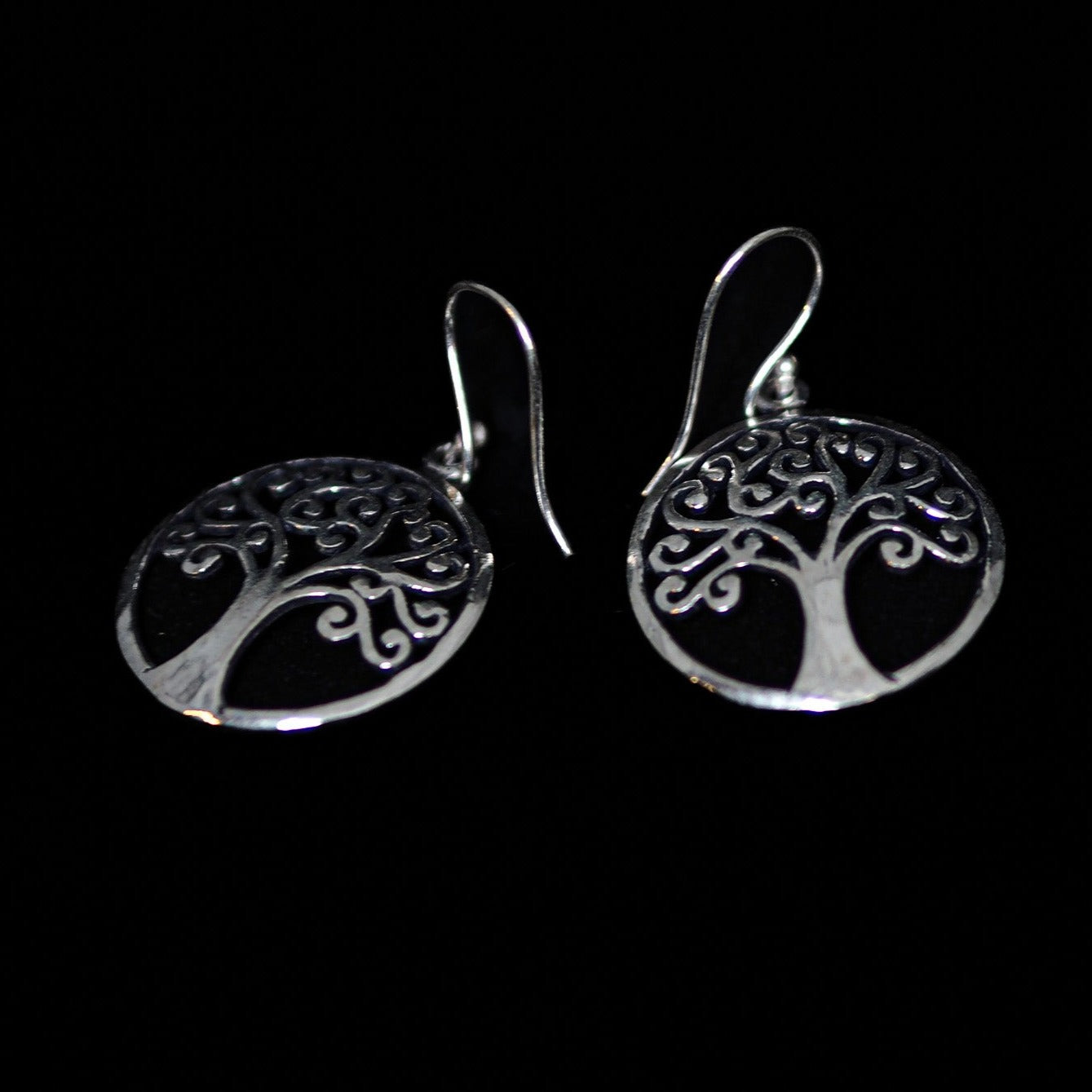 Silverfärgade Tree of Life hängörhängen med ornament träd- och rotmotiv på svart bakgrund