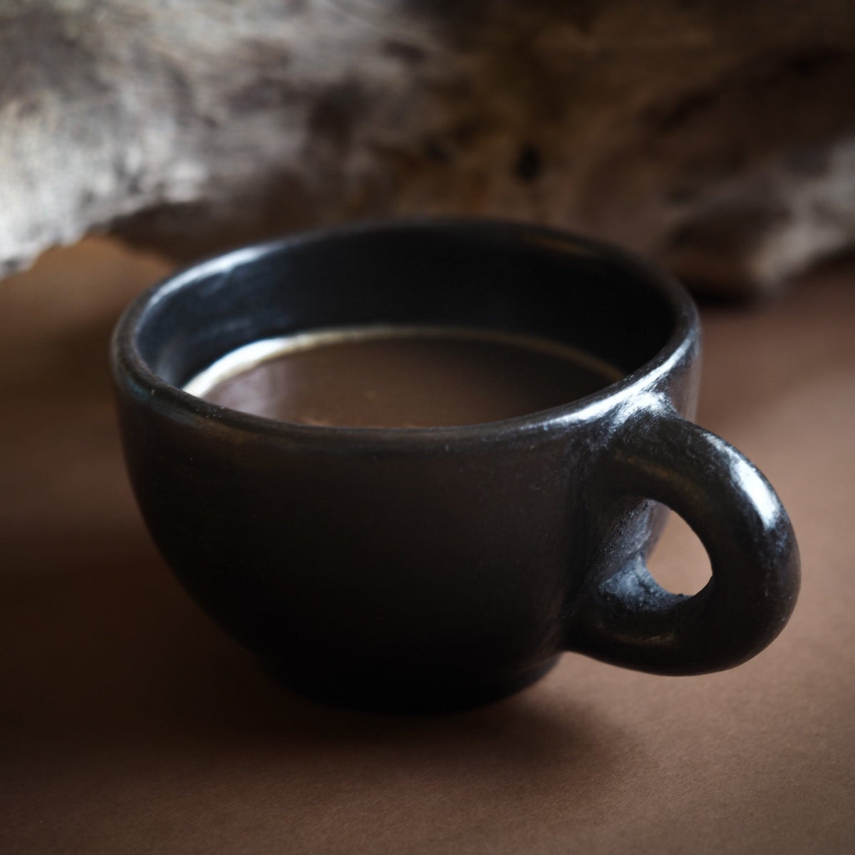 Svart eldad lerkoppar med öra i Birka-inspirerad stil. Glänsande svart yta från milbränning. Rund form med robust handtag.