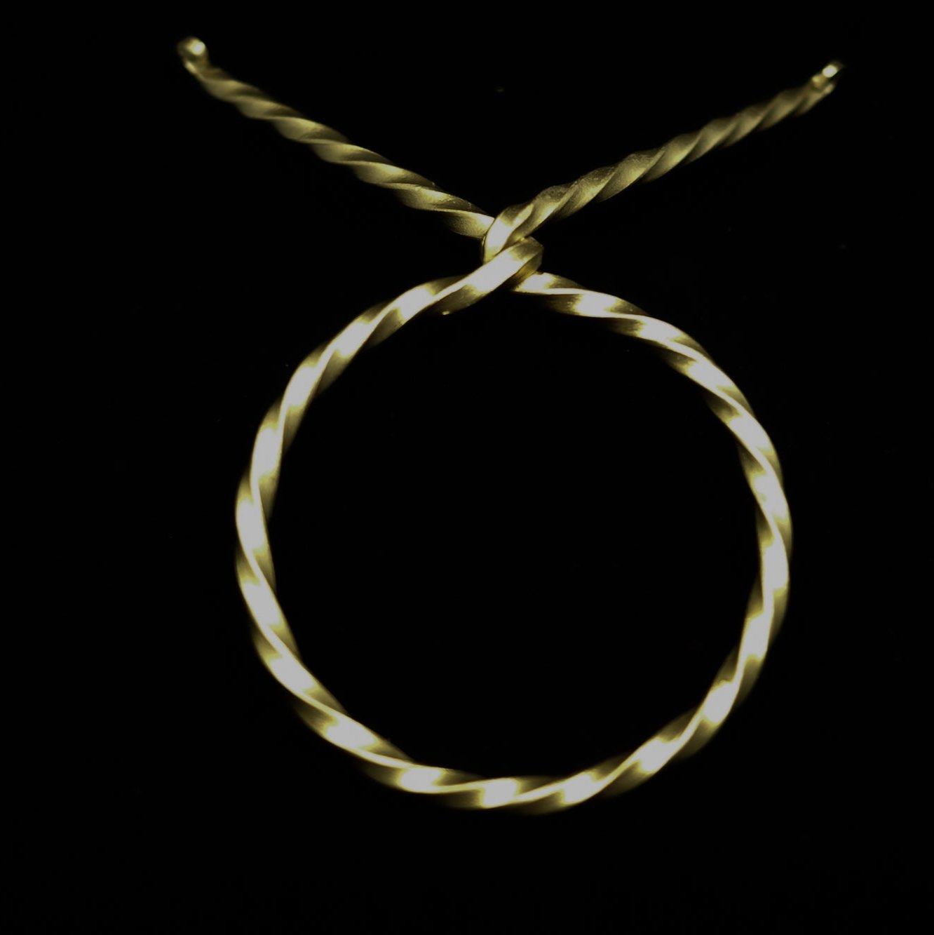 Dryckeshorn i guld-ton järnstativ från ovan, visar hornets naturliga färg och järnbandens spiralform