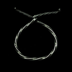 Översidesvy av polerad dryckeshorn i järnstativ på mörk bakgrund, visar hornets naturliga form och glans