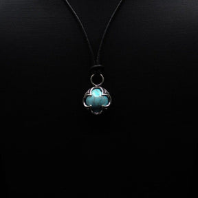 Turkoshängsmycke sett från under. Mässingsfattningen är fyrledad med keltiska knutverk. Stenen visar naturliga sprickornament karakteristiska för turkos.