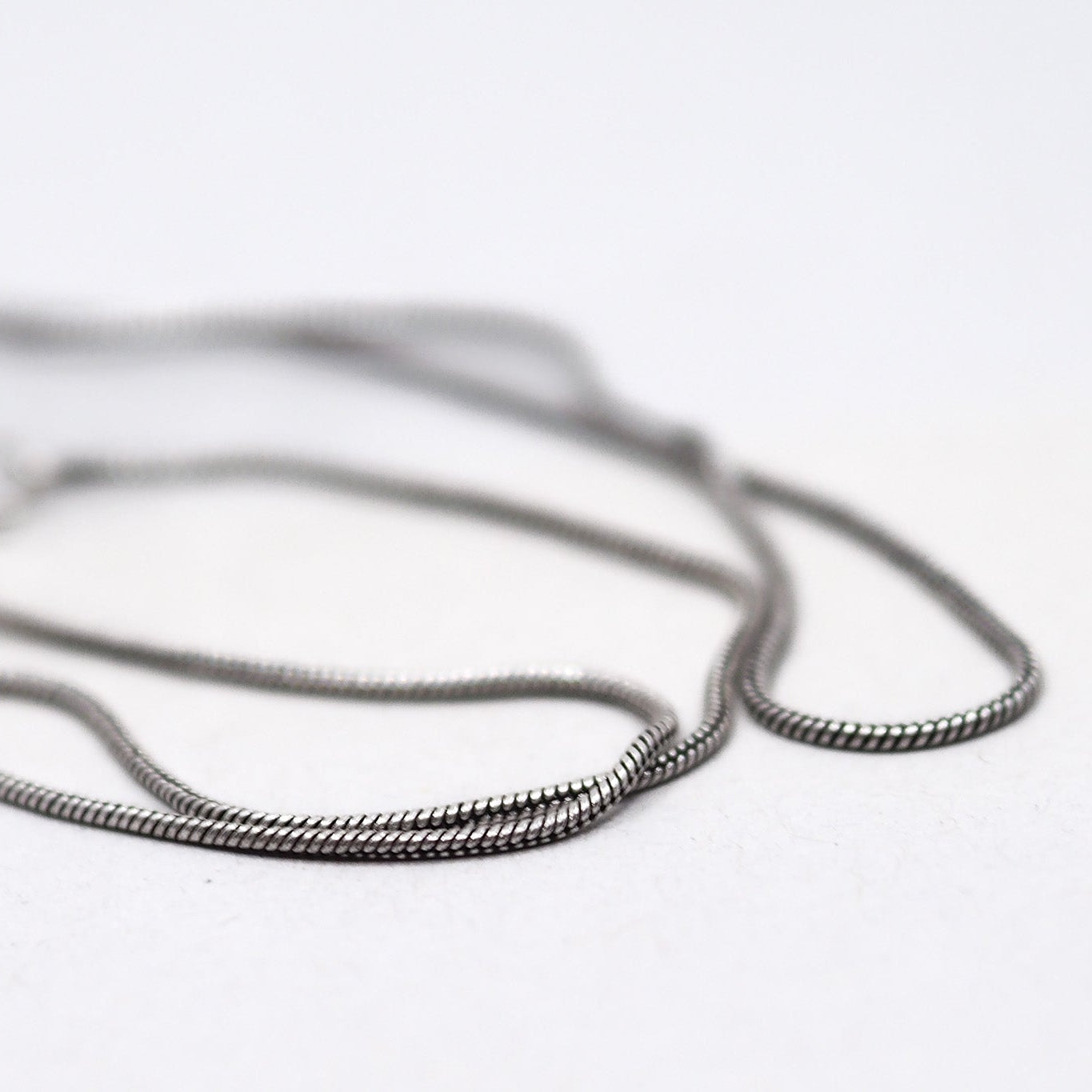 Närbild av silverplätering halskedja med detaljerad länkstruktur och fin maskämne