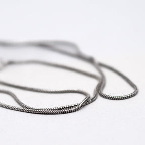 Närbild av silverplätering halskedja med detaljerad länkstruktur och fin maskämne