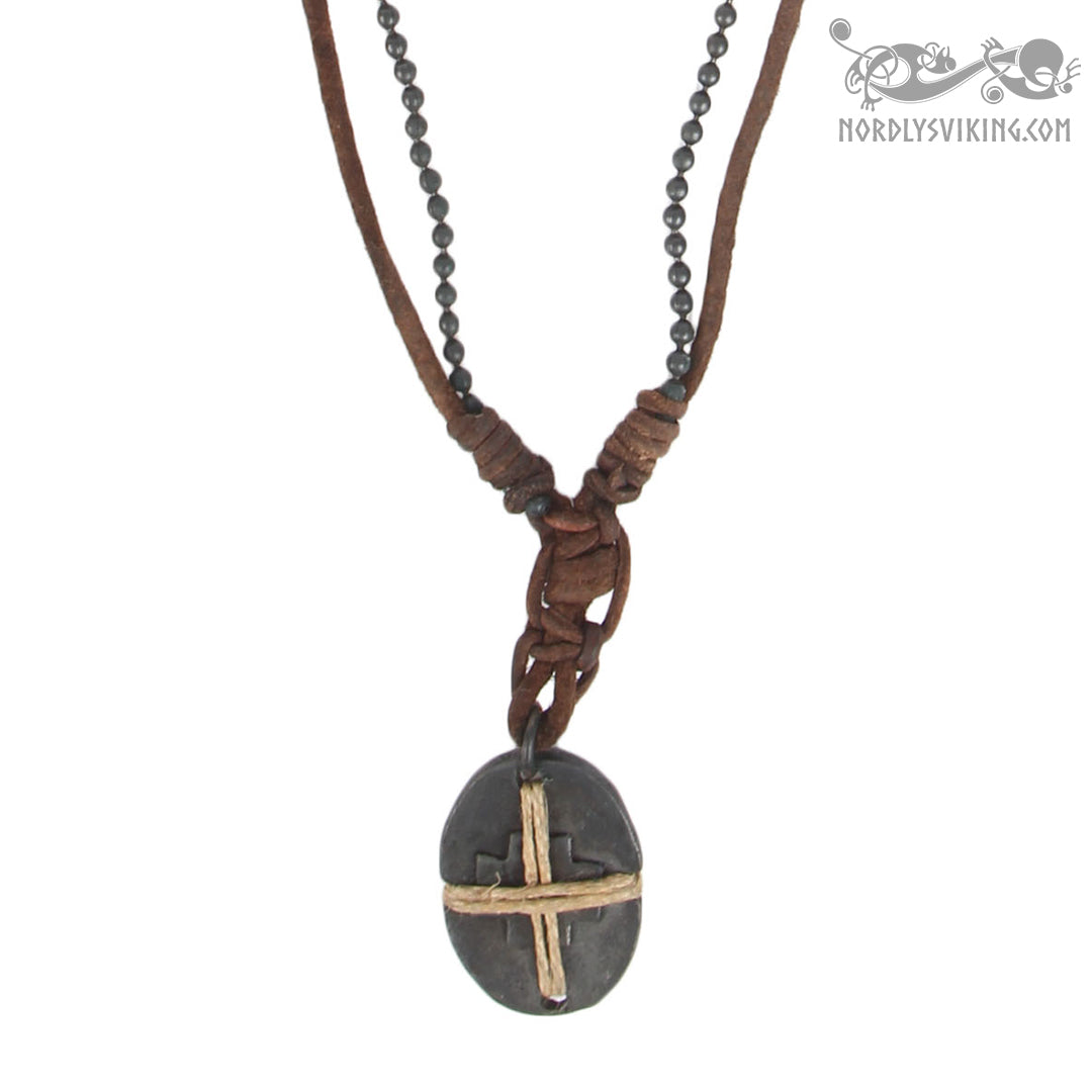 Halsband Byzans presenterad från framsidan på vit bakgrund. Visar två bruna läderband med pärlor, pilgrimskorsdesign med ovalt hänge och krusdetaljer.