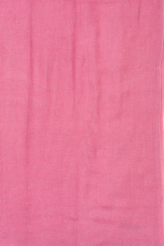 Närbild av rosa kashmir sjals twillväv, visar fintvävd ullkvalitet och hantverk med detaljerade texturer.