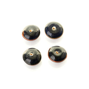 Fyra mörkblå glaspärlor med brunt dekorativ ring runt mitten. Perlorna visar arkeologisk patina och är ursprungliga fynd från vikingaperioden, fotograferade mot vit bakgrund.