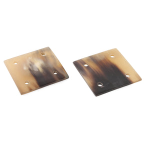 Två hornbrickor för brickväv på vit bakgrund, visar ljus och mörkfärgad horn med naturliga ådringar och inristade vikingtecken