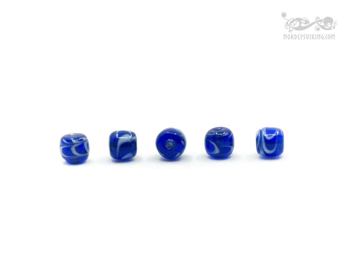 Fem blå glaspärlor med vit dekorativ mönster från Kaupang, Norge - arkeologisk original från vikingatiden